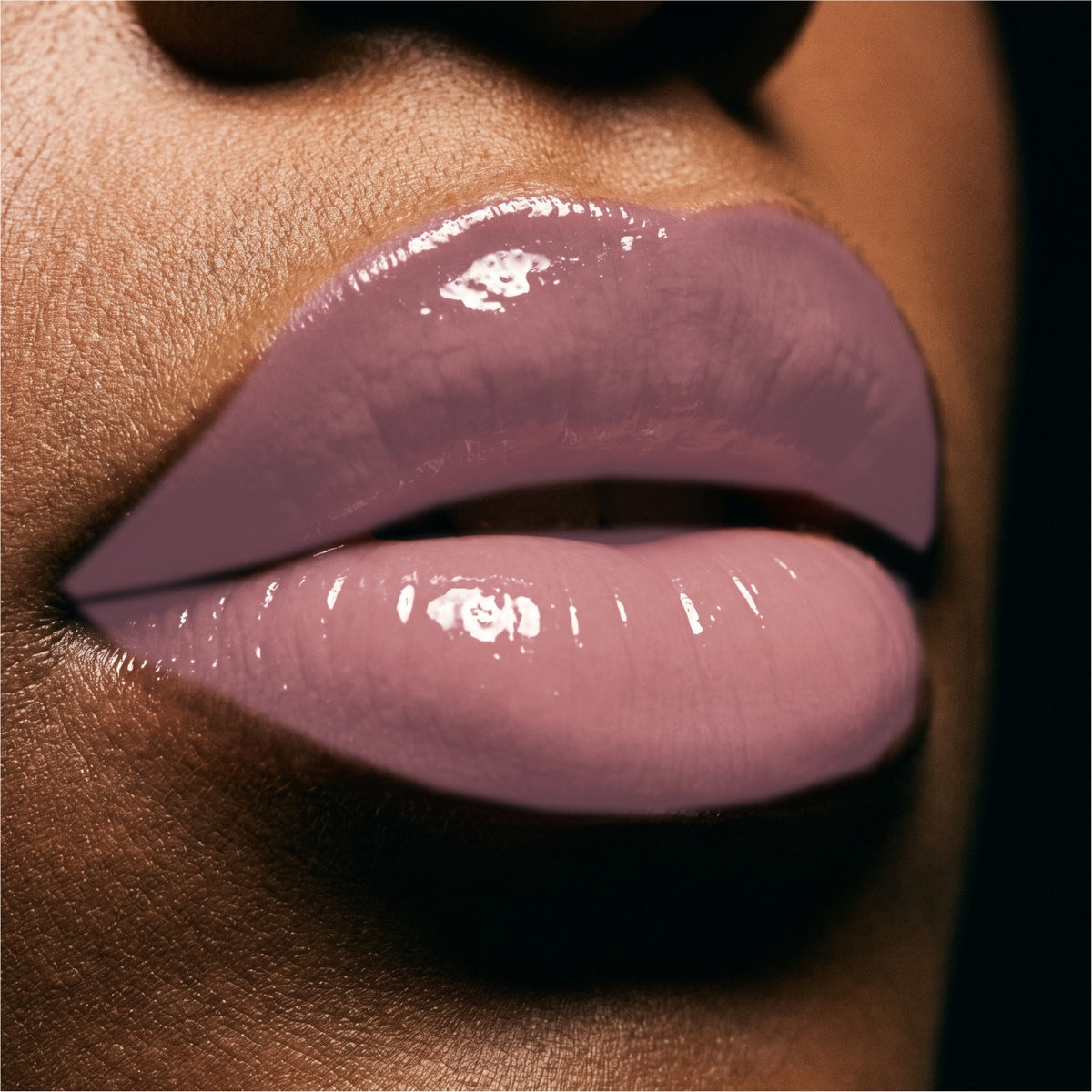 Close-up of glossy Pink Champagne lips with a high-shine lip product on a model's face.